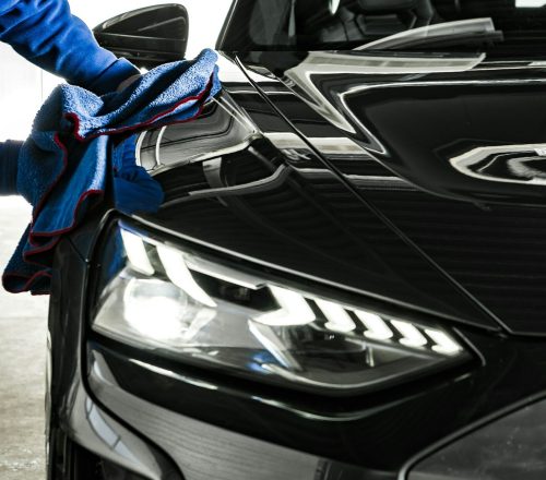 Car Wash and Detailing Worker Cleaning a Car with Soft Cloth