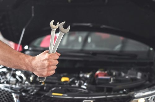 Mechanic holding pair of wrenches at the repair garage